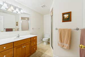Bathroom featuring a wood-finish vanity with an integrated sink and a white countertop