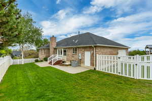 Spacious backyard featuring a lush green lawn, full privacy fencing, and mature trees
