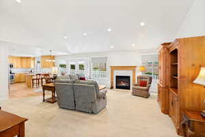 Expansive living area featuring a fireplace with a wood mantle, recessed lighting, and a bay window