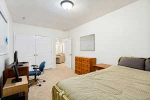 Carpeted room featuring white walls, a single window with blinds, and white bi-fold closet doors