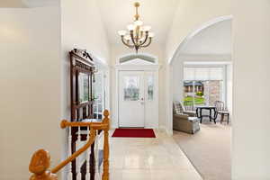 Inviting entryway featuring a leaded glass front door, transom window, and a decorative chandelier