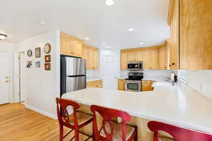Kitchen featuring light wood cabinetry and light-toned countertops