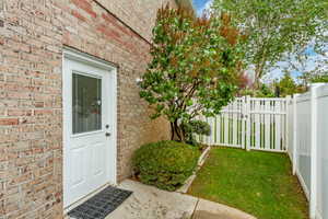 Brick exterior with a white entry door featuring a clear glass insert