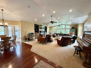 Expansive living area featuring vaulted ceilings, recessed lighting, and a wall of arched windows
