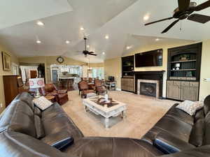 Spacious living area featuring vaulted ceilings, recessed lighting, and ceiling fans