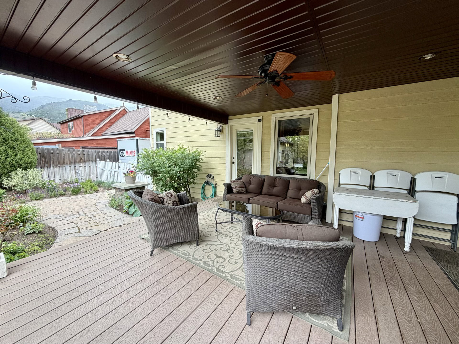 Expansive covered deck featuring composite decking, a ceiling fan, recessed lighting, and string lights