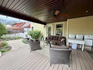 Expansive covered deck featuring composite decking, a ceiling fan, recessed lighting, and string lights