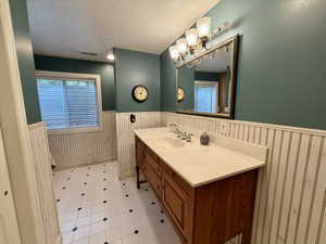 Double vanity with integrated sinks, light-toned countertop, and wood-finish cabinetry