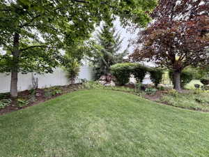 Expansive lawn area bordered by a white privacy fence
