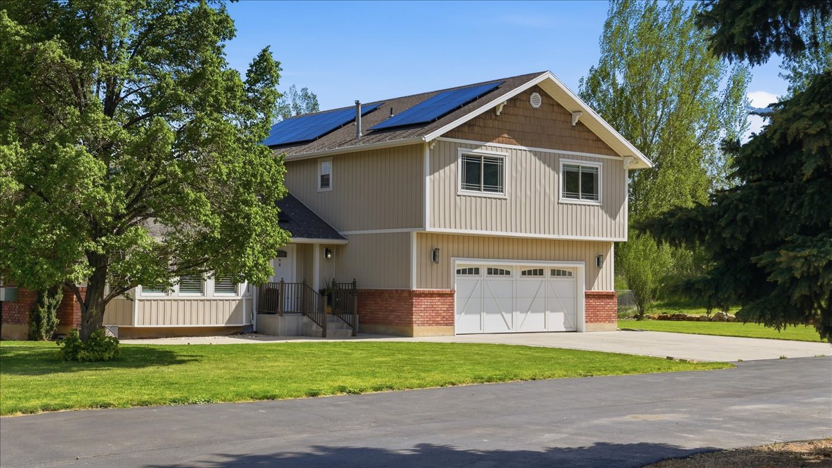 Two-story residence featuring light-colored vertical siding and brick accents