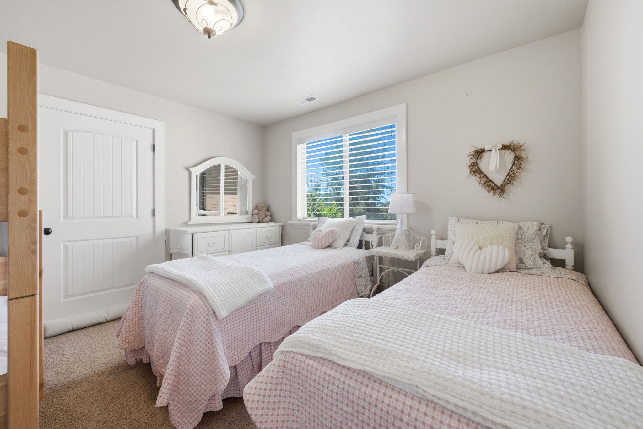 Bedroom featuring neutral wall paint, carpet flooring, a window with horizontal blinds, and a white paneled door