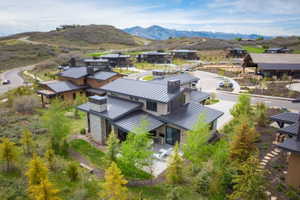Modern residence featuring a metal roof, stone and stucco exterior, and a private outdoor patio