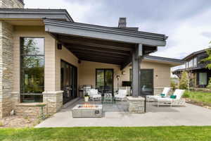 Expansive concrete patio featuring an integrated fire pit, providing an outdoor entertaining space
