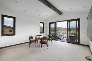Bright interior space featuring a vaulted ceiling with exposed wood beams, recessed lighting, and integrated ceiling speakers