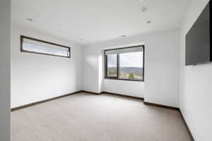 Bright room featuring a large picture window with mountain scenery and an additional horizontal window