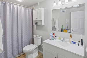 Basement apartment bathroom featuring a single vanity with an integrated sink, large wall-mounted mirror, and overhead vanity lighting