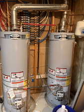 Dual hot water heaters featuring copper piping and a centralized PEX manifold system