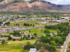 Expansive aerial perspective showcasing a residential and commercial area with prominent mountain terrain in the background