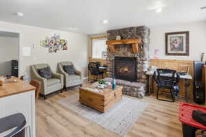 Stone-clad fireplace with a natural wood mantel