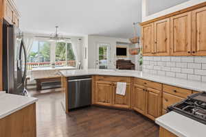 Gourmet kitchen featuring wood-finish cabinetry, white countertops, and a subway tile backsplash