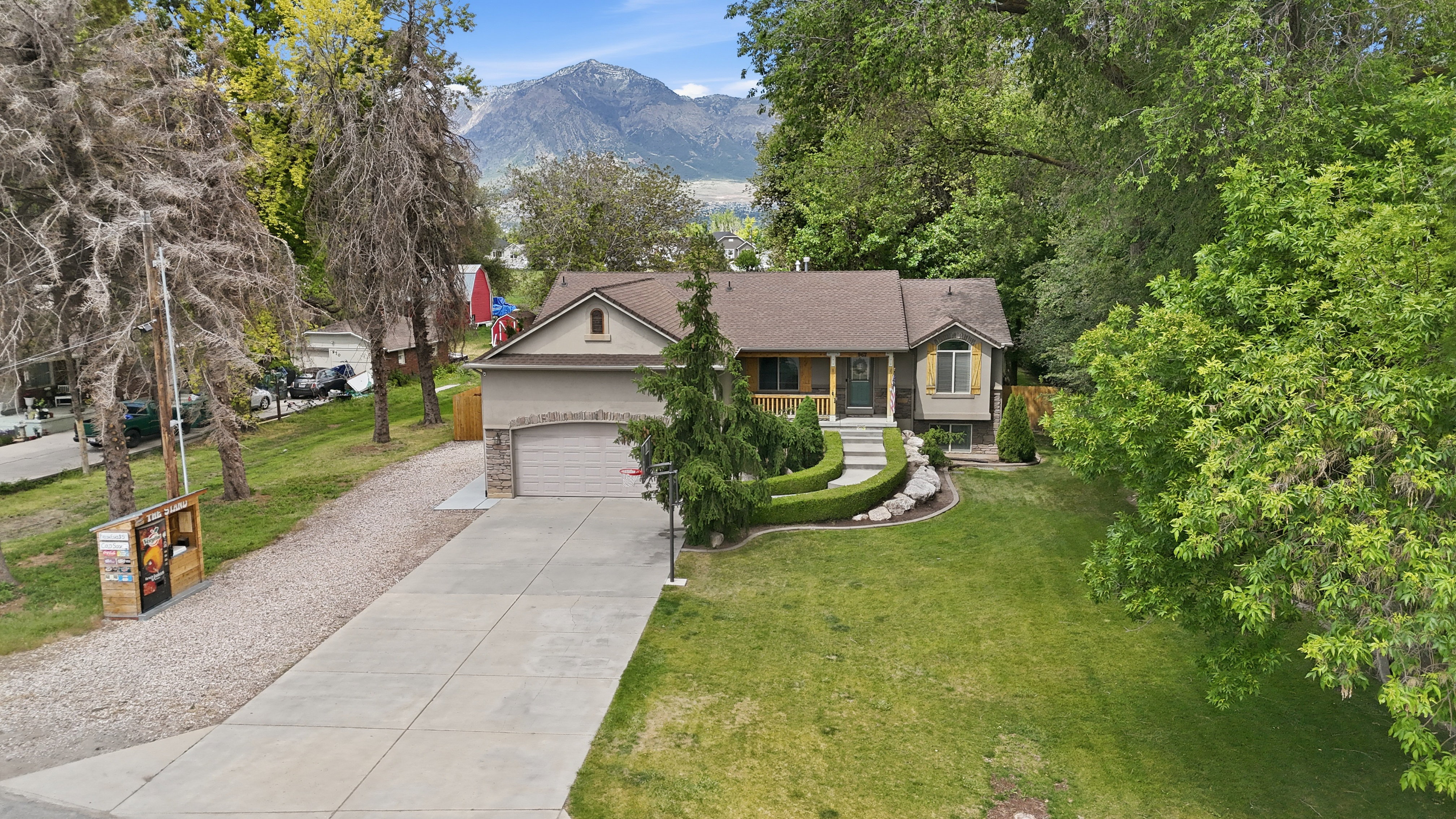 Traditional-style residence featuring a two-car garage, concrete driveway, and established landscaping