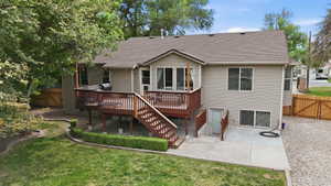 Rear exterior with a multi-level wood deck and stairs leading to a concrete patio