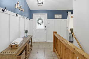 Entryway featuring board and batten wall paneling, a full light front door, and ceramic tile flooring