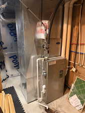 Furnace and ductwork system featuring a Carrier brand unit, PVC piping, and galvanized sheet metal ducts