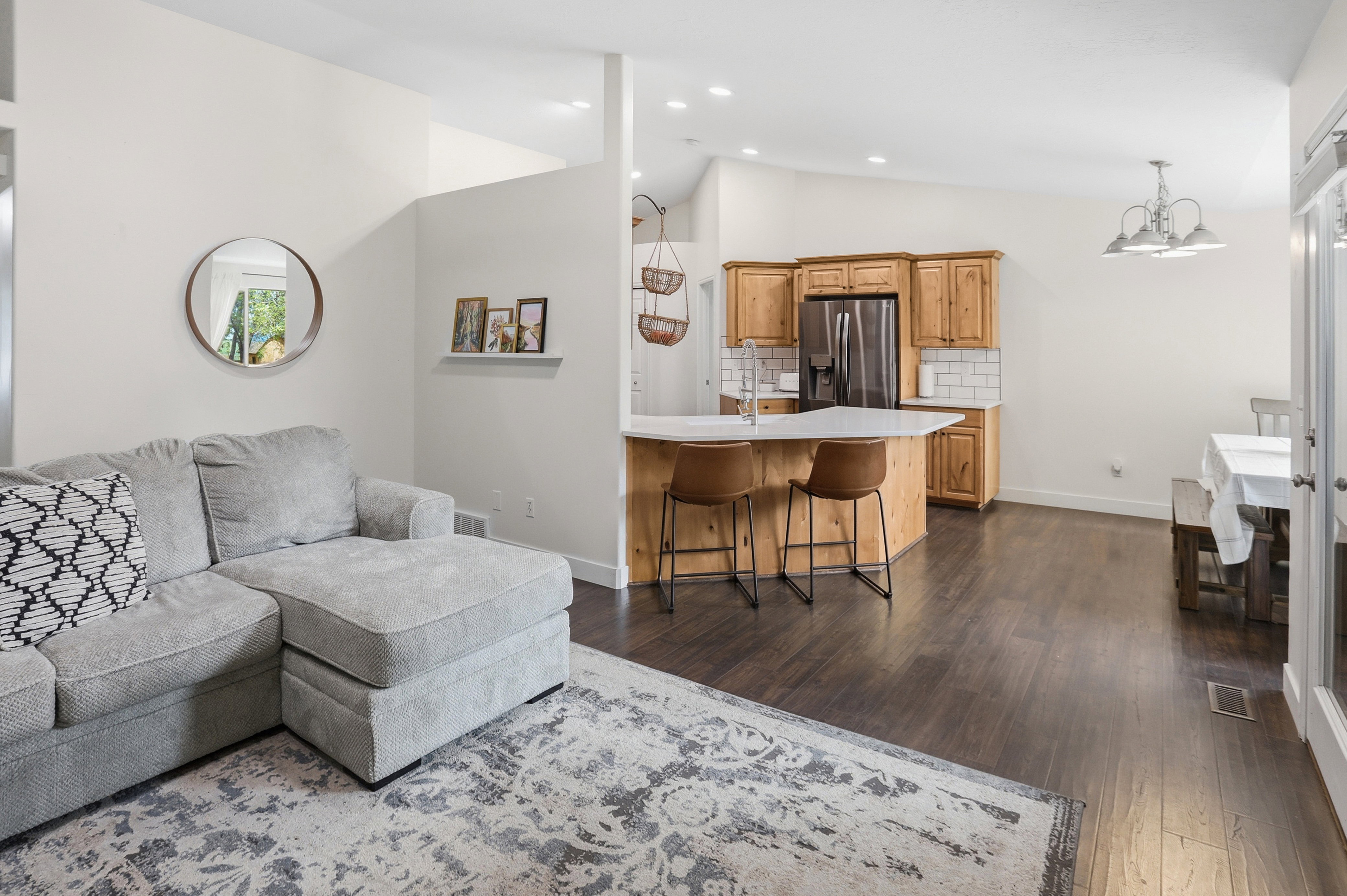 Open-concept living area featuring wood-finish flooring, vaulted ceilings, and recessed lighting