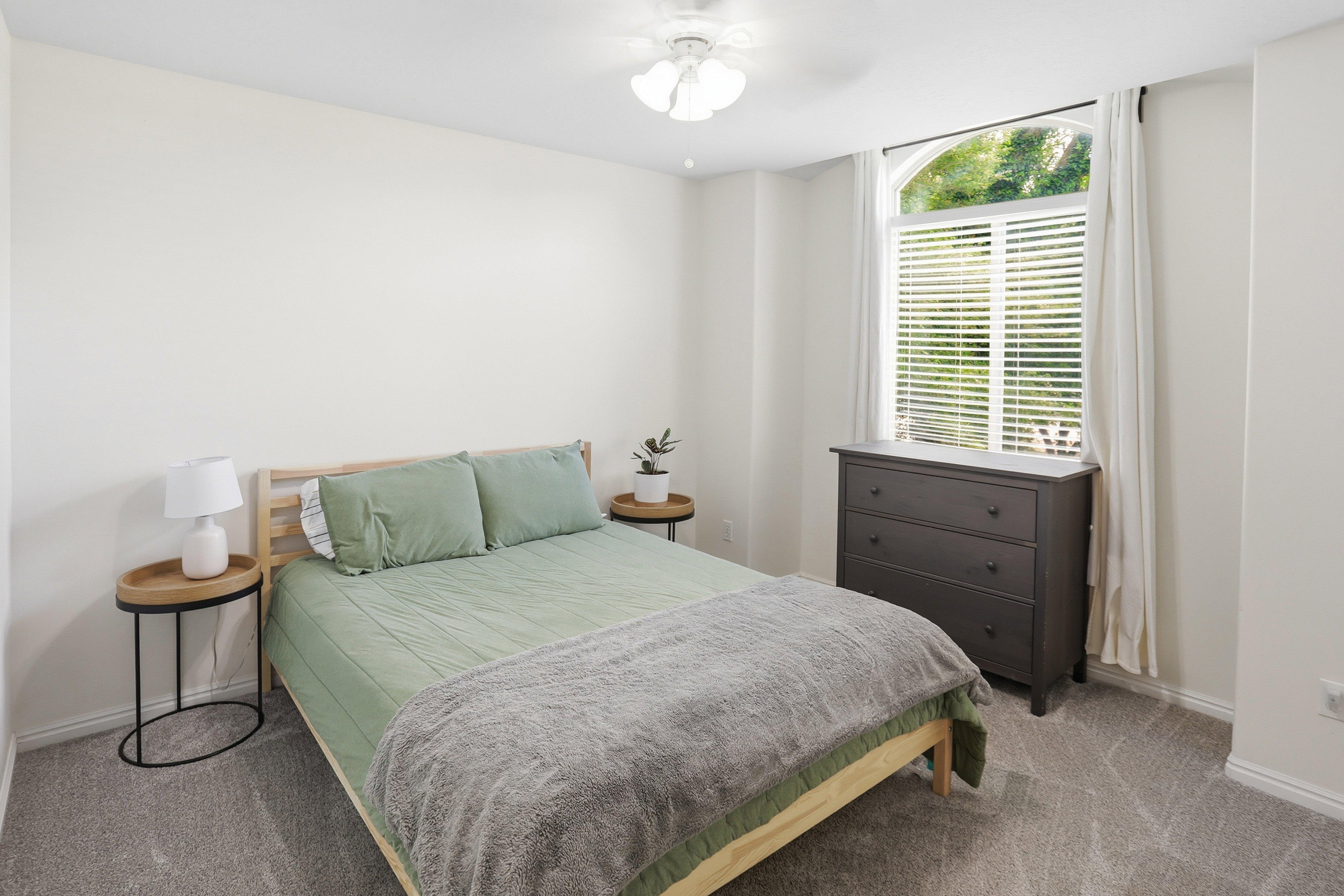 Arched window with blinds and white drapes