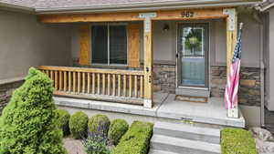 Covered front porch featuring rustic wood columns and railing