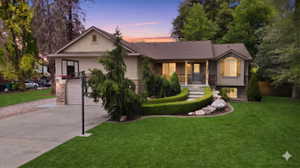 Contemporary home exterior featuring a multi-tone facade, arched window with shutters, a covered porch entry, and a two-car garage