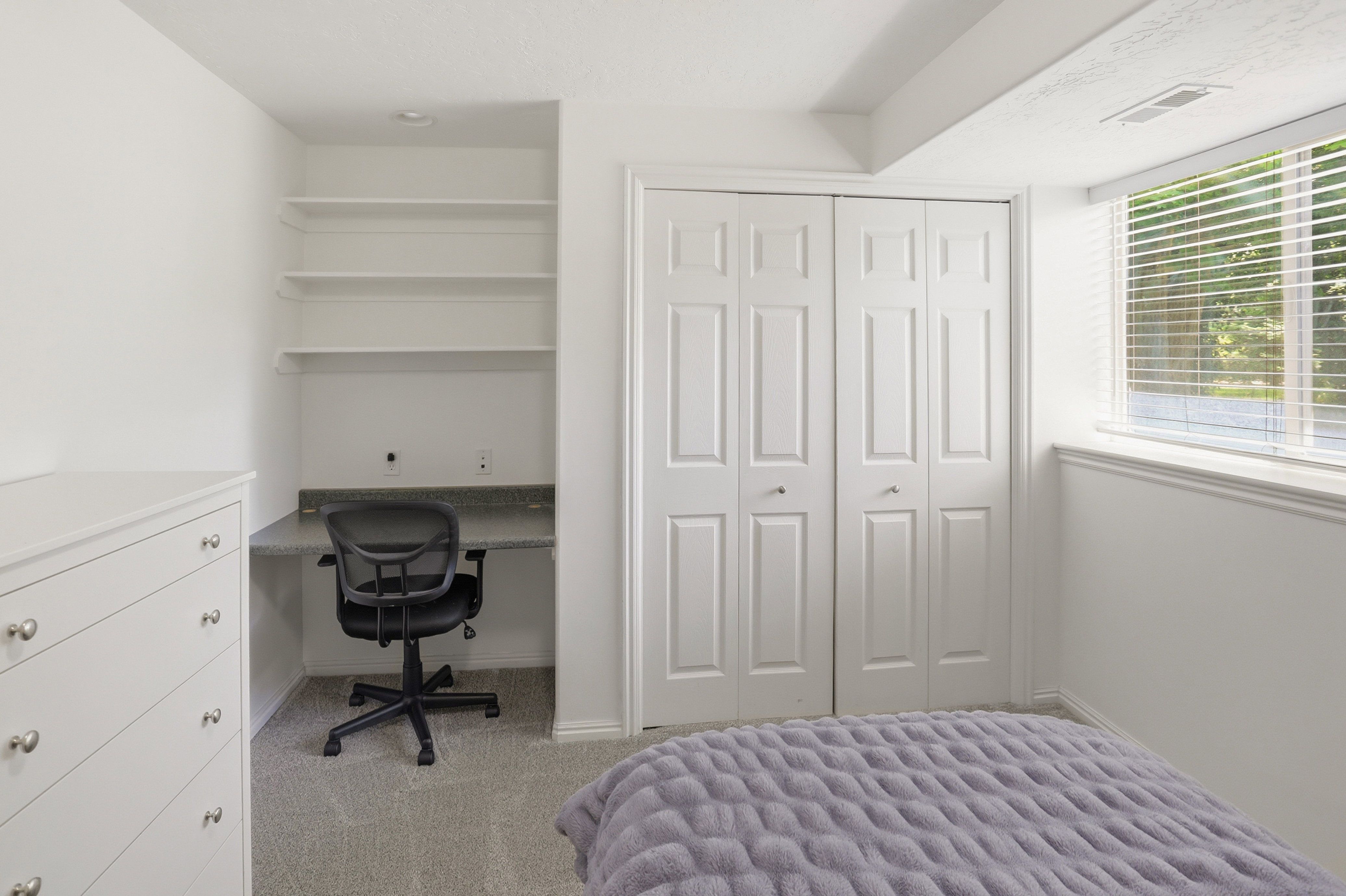 Built-in desk with a stone-finish countertop and open shelving