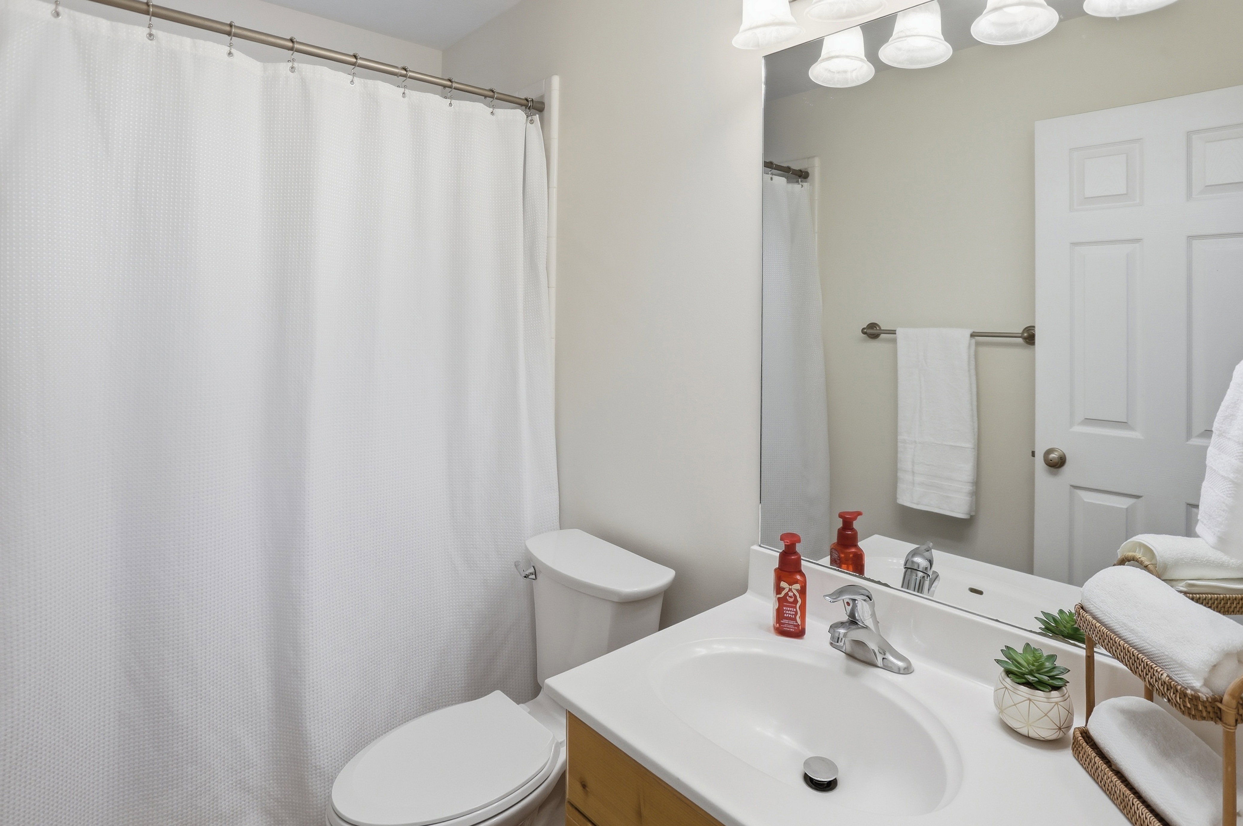 Bathroom featuring a vanity with a white countertop, chrome faucet, and a large wall-mounted mirror