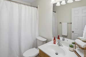 Bathroom featuring a vanity with a white countertop, chrome faucet, and a large wall-mounted mirror