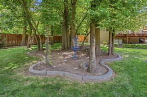 Expansive backyard featuring a central tree cluster with decorative stone edging