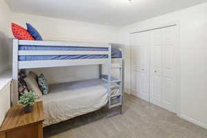 Carpeted room featuring light-colored walls and a bi-fold closet with white panel doors
