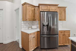 Kitchen area featuring wood cabinetry, white countertops, and a subway tile backsplash