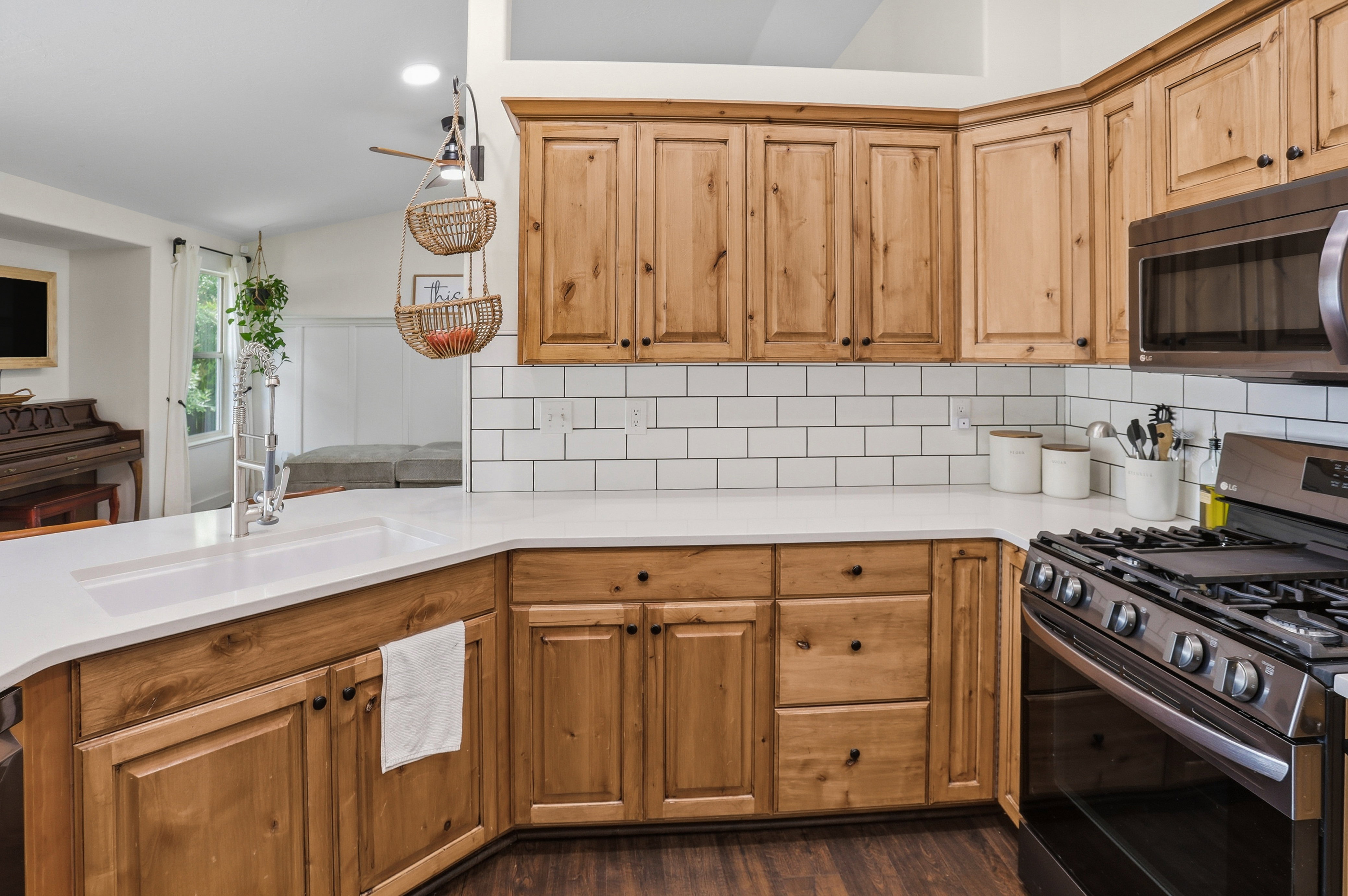 Kitchen featuring wood-finish cabinetry, white countertops, and subway tile backsplash