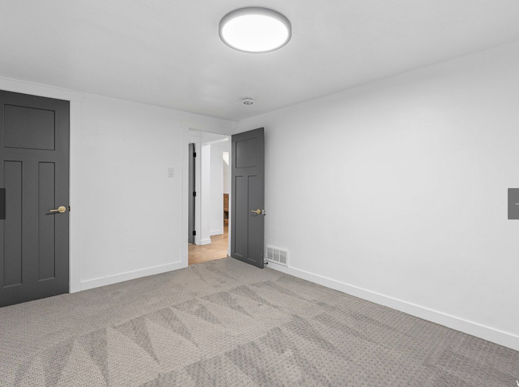 White-painted walls complement the light-colored carpet flooring