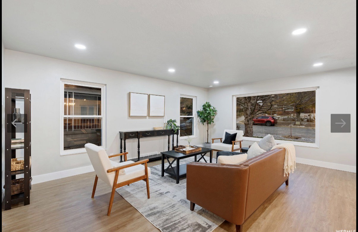 Light-filled living area featuring recessed lighting, light-toned walls, wood-finish flooring, a large picture window, and an additional window