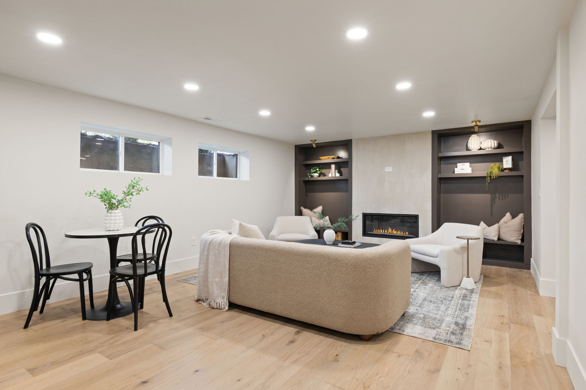 Spacious living area featuring wood-finish flooring, recessed lighting, and a modern linear fireplace