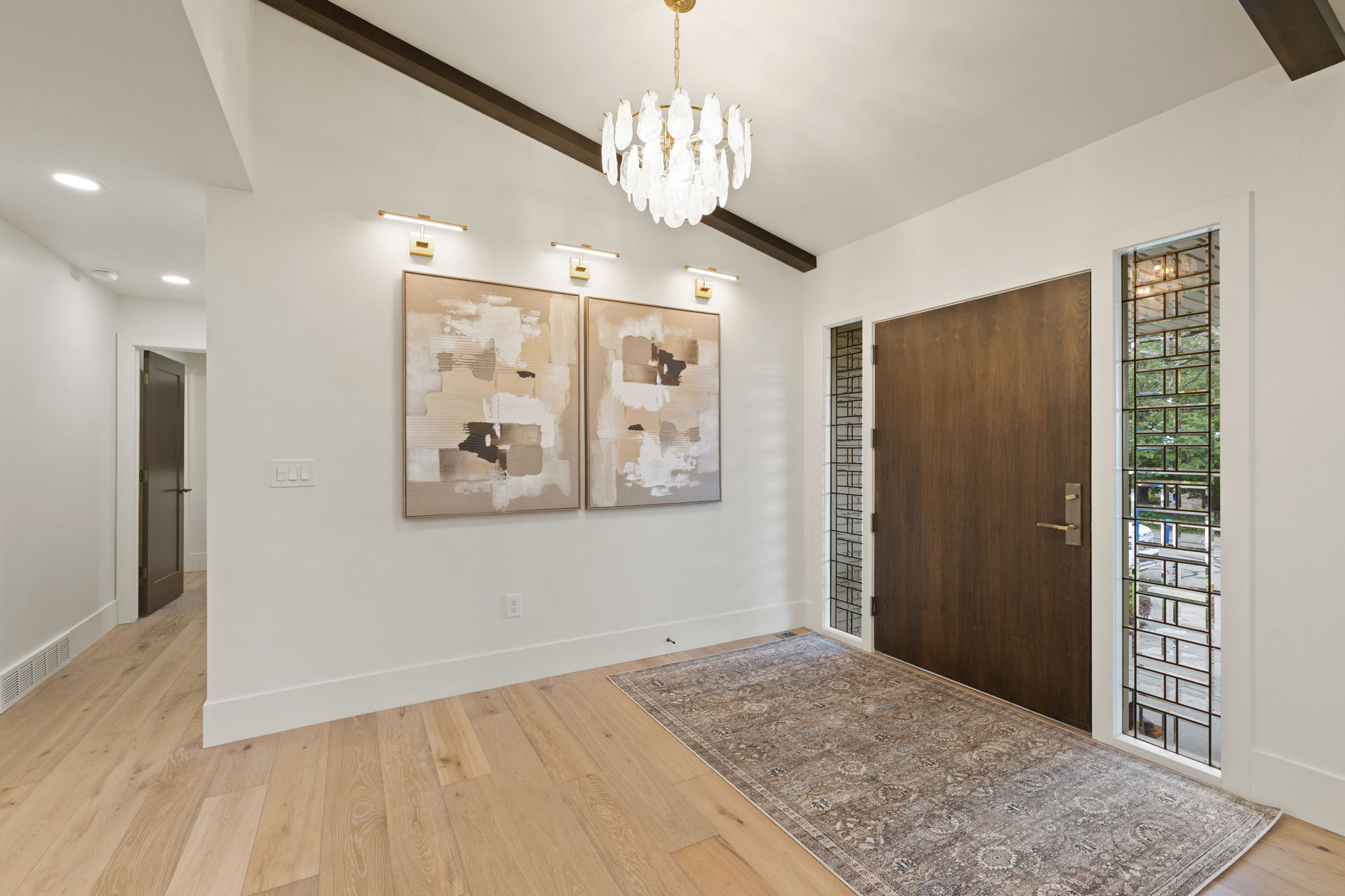 Entryway featuring a dark wood door with brushed nickel hardware, surrounded by decorative glass sidelights with metal grilles