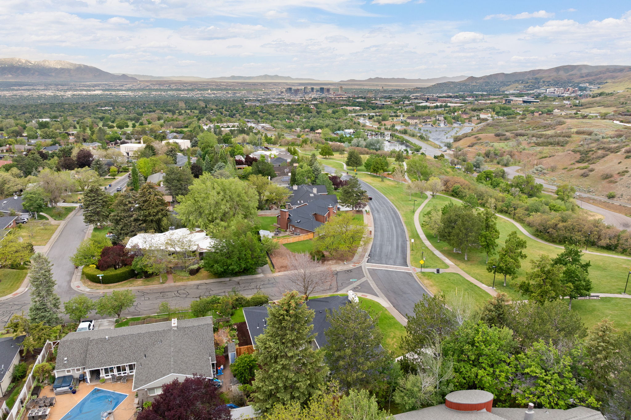 Aerial perspective showcasing a residential area with mature trees and extensive green spaces