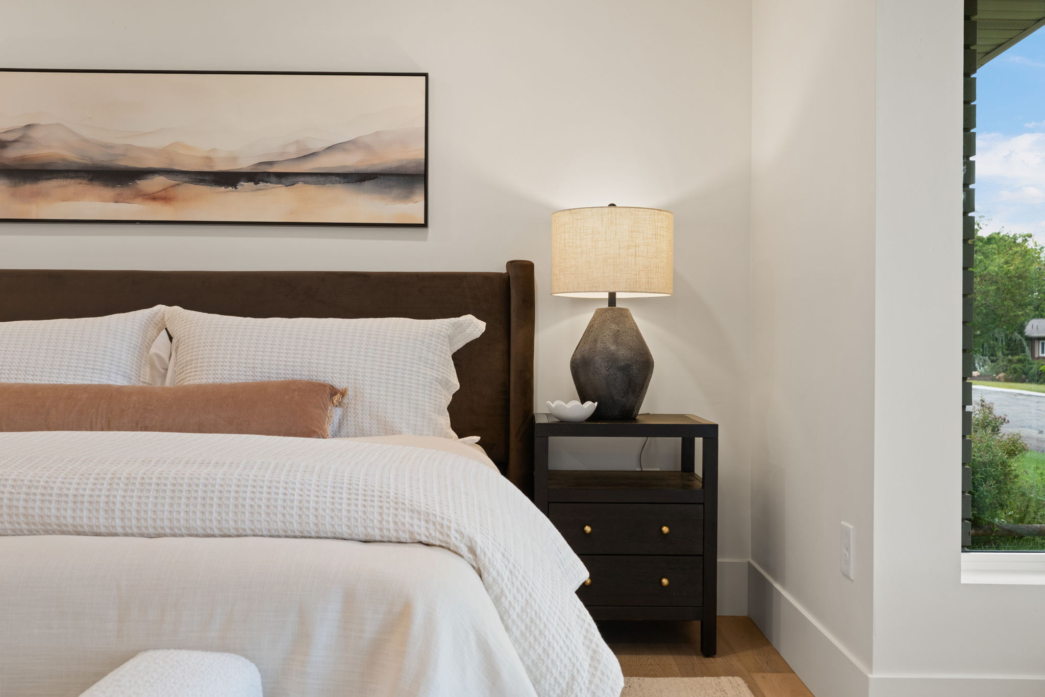 Hardwood-style flooring extends to a prominent window with louvered blinds