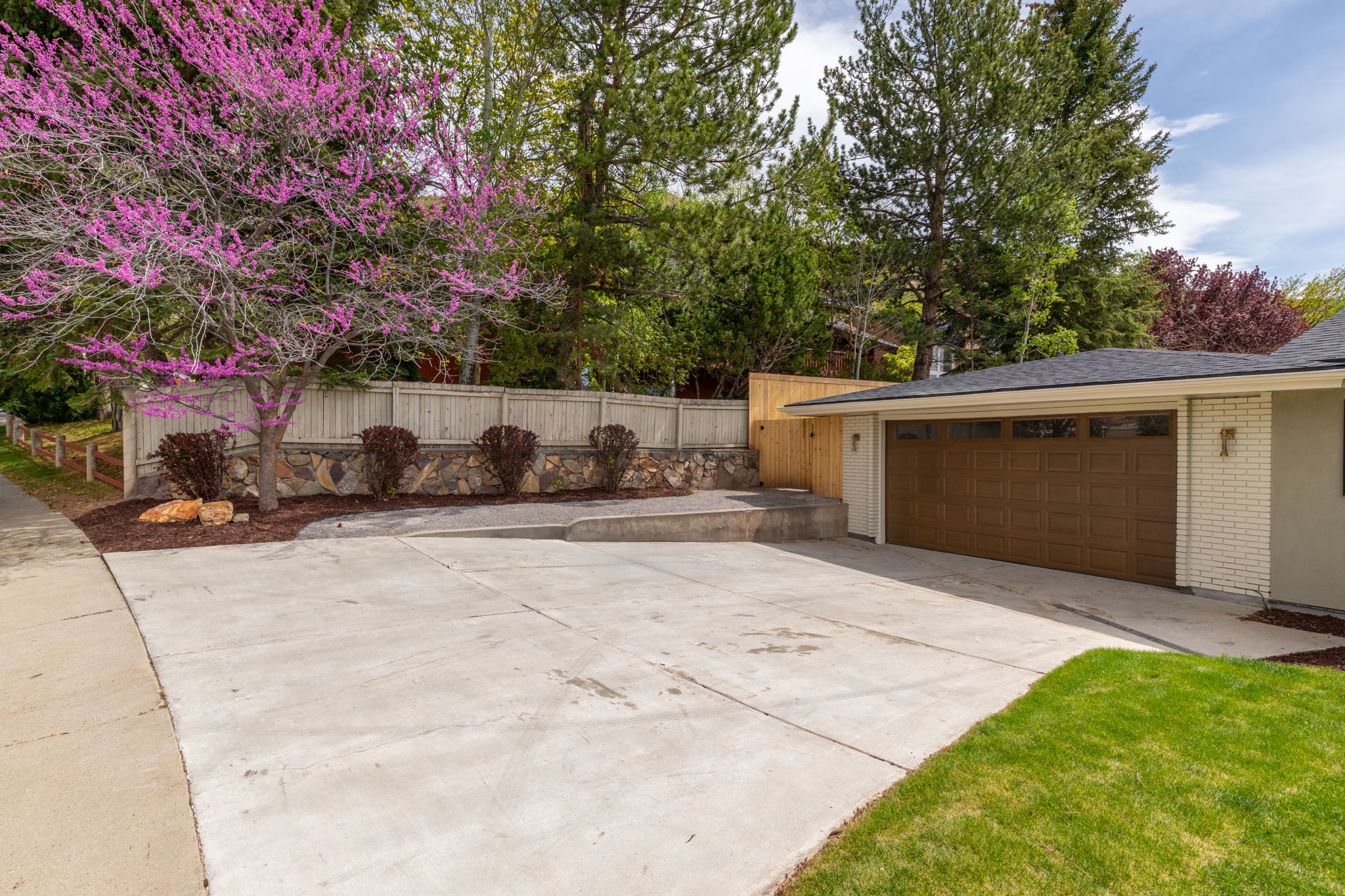 Concrete driveway with integral garage featuring a wood-finish garage door