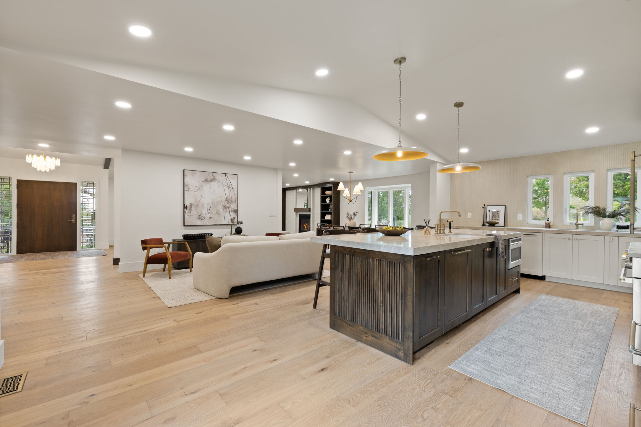 Expansive open-concept living space with light wood-finish flooring