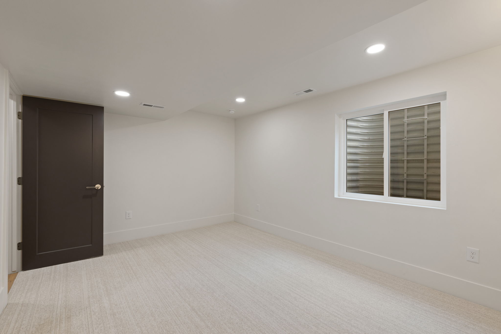 Room featuring light-toned carpeting, white walls, and recessed lighting