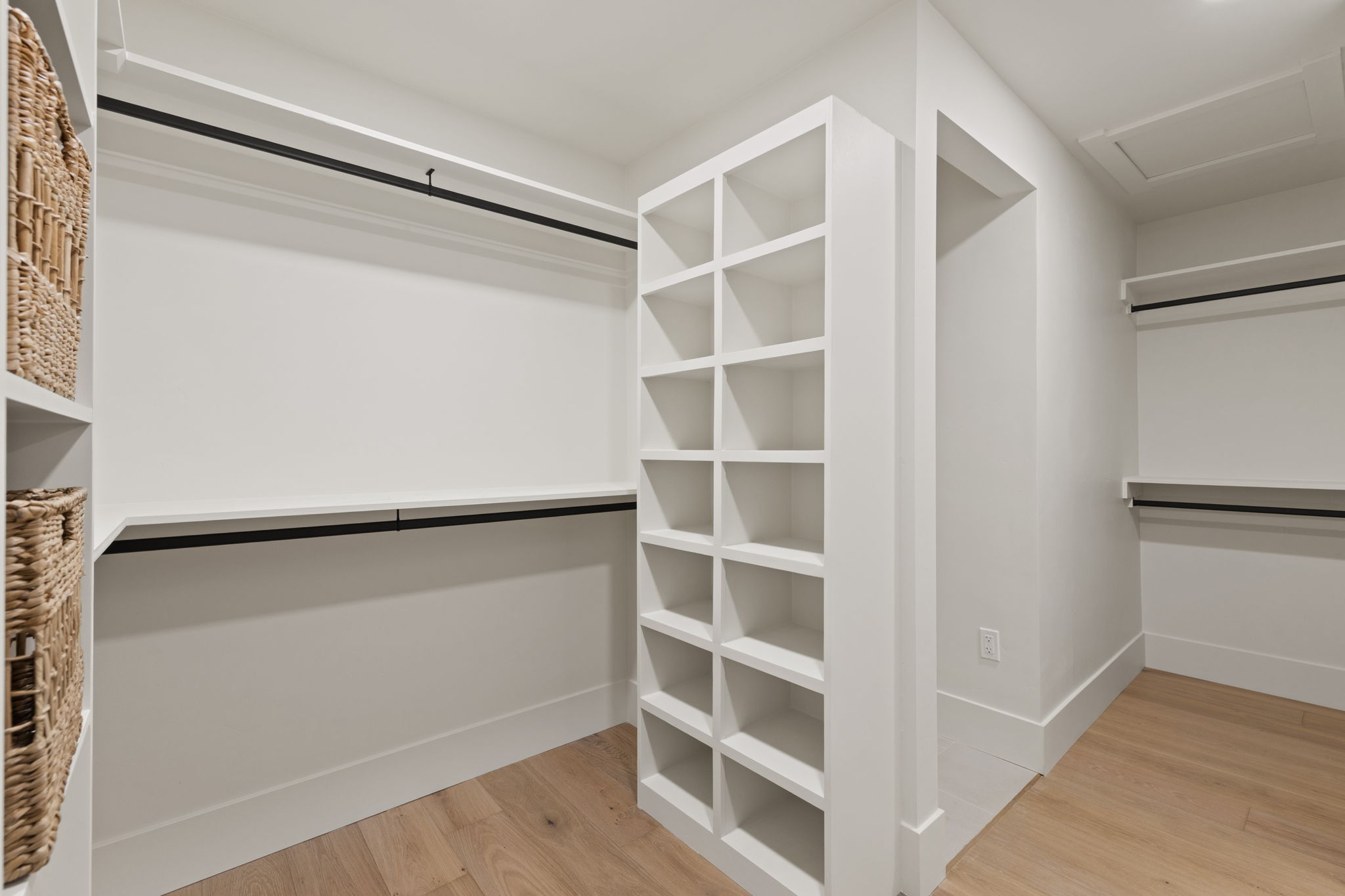 Customizable closet system featuring extensive shelving, hanging rods, and wood-finish flooring
