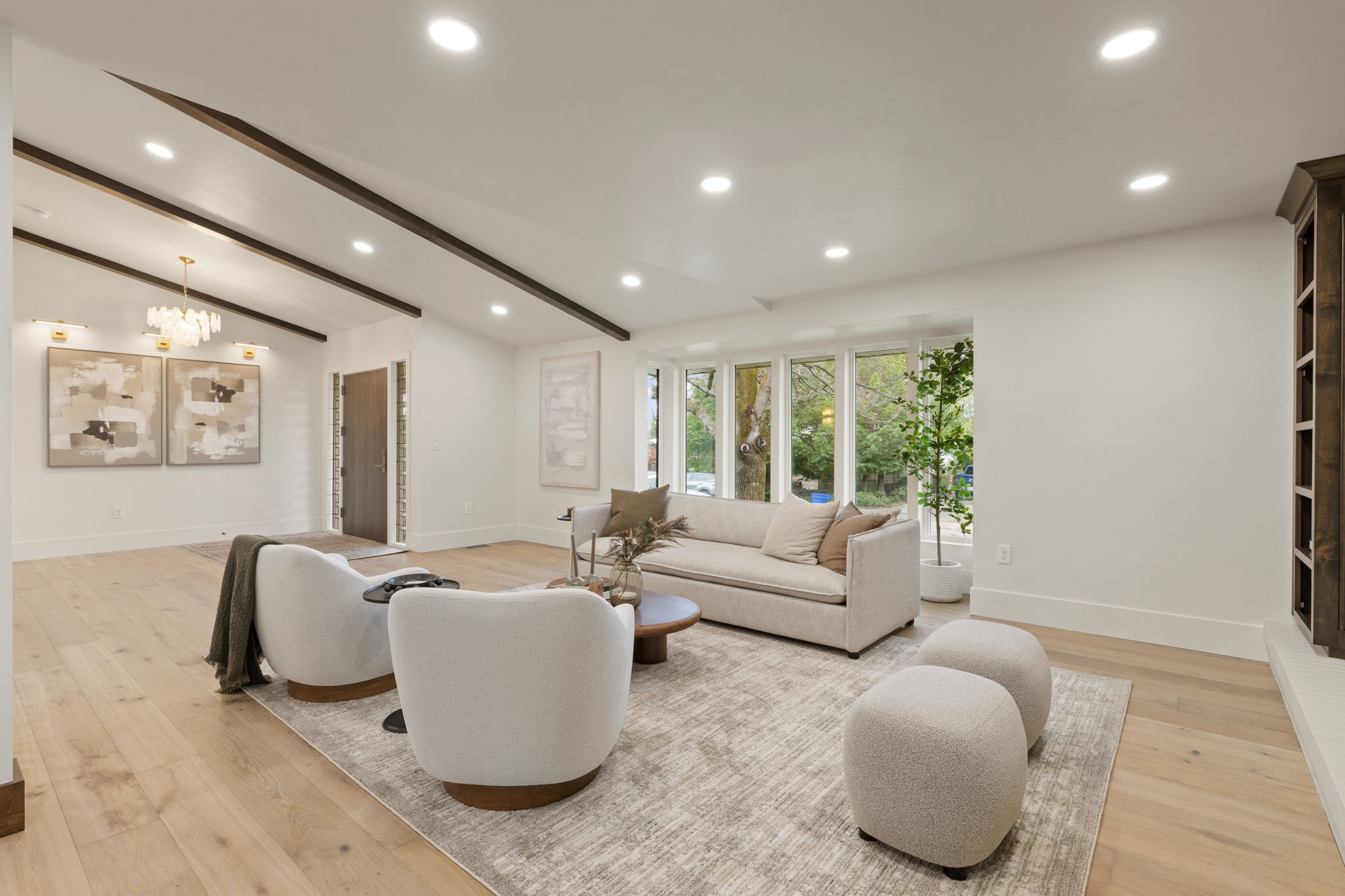 Vaulted ceiling with exposed wood beams, recessed lighting, and light wood-finish flooring